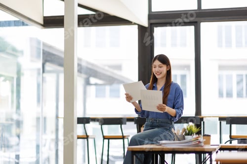 Preview: Happy young asian woman reviewing business documents