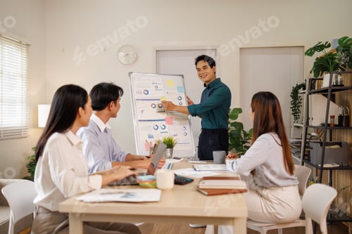 Preview: Asian business team collaborating on financial data presentation