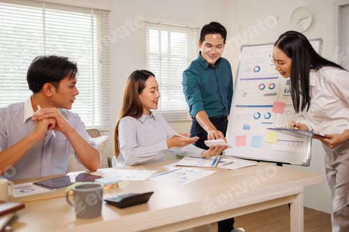 Preview: Asian business team collaborating on financial strategy in office