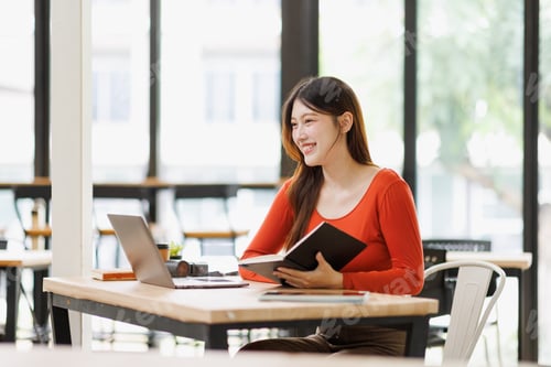 Preview: Young woman learning and working on laptop at cafe