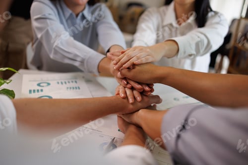 Preview: Business team stacking hands showing unity and working together
