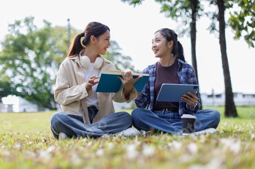 Preview: Asian college students studying together outdoors in park