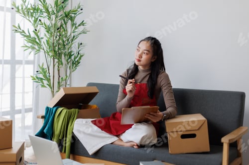 Preview: Young Asian woman planning small business e-commerce strategy