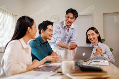 Preview: Asian business team collaborating on laptop in office meeting