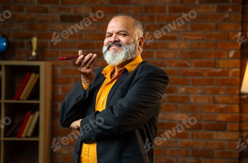 Preview: Experienced Indian Corporate Executive Using Smartphone Speaker In A Cozy Office
