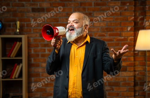 Preview: Cheerful Experienced Indian Executive Shouting Through Megaphone In A Cozy Office