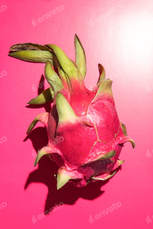 Preview: One large beautiful pink dragon fruit on a bright pink background. vertical top view. shade from the