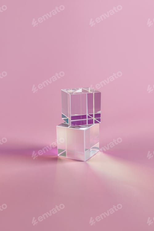 Preview: Two transparent cubic prisms on a pink background with a beautiful refractive spectrum. vertical fro