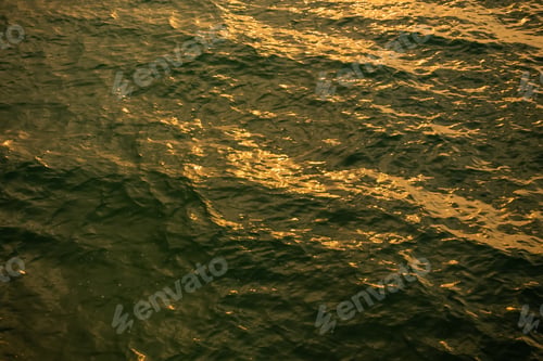 Preview: Ocean Surface at Sunset with Golden Reflections and Dark Blue Waves