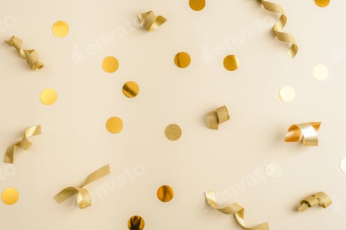 Preview: Holiday background made of golden tinsel and sparkling confetti on neutral backdrop. Festive concept