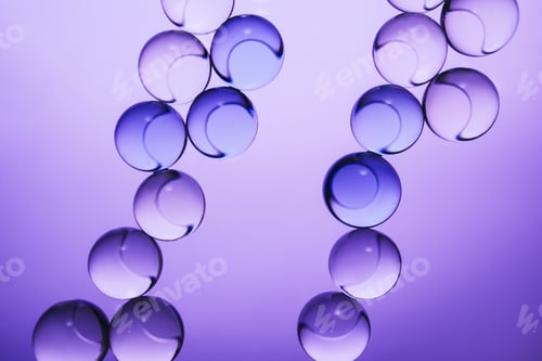 Preview: Transparent spheres creating an abstract chains pattern with reflections on purple background