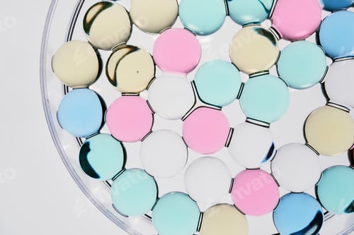 Preview: Circular droplets floating on clear liquid forming soft pastel abstract background