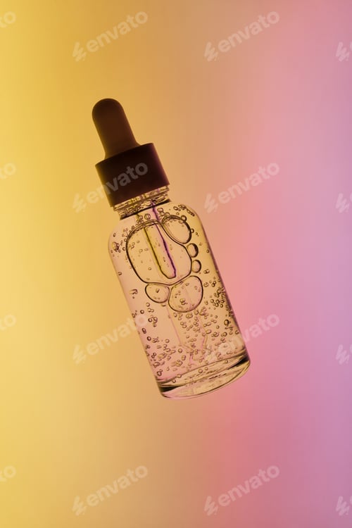 Preview: Dropper bottle containing clear serum with bubbles, representing beauty and wellness