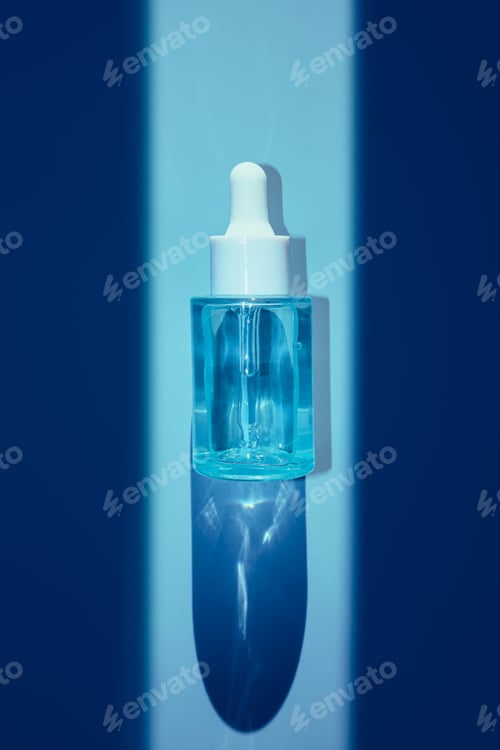 Preview: Blue cosmetic serum dropper bottle standing with shadow on monochromatic blue background