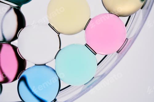 Preview: Colorful translucent glass spheres in petri dish forming minimalist abstract pattern