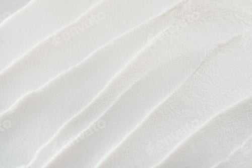 Preview: White cosmetic cream creating abstract brushstrokes and smooth waves on surface