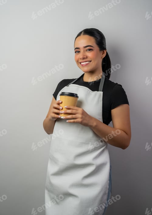 Preview: Young woman barista posing while holding a takeaway coffee cup