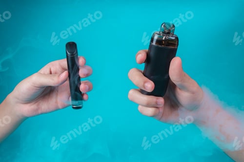 Preview: Two Hands Holding Different Electronic Cigarettes With Smoke On Blue Background