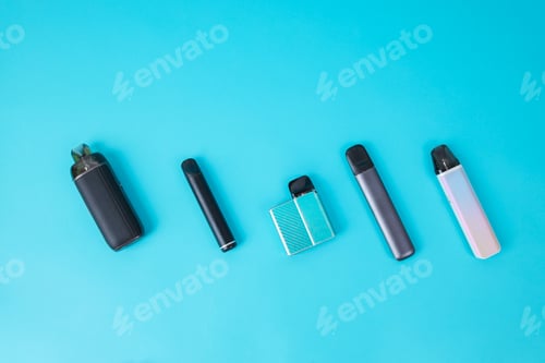 Preview: Flat Lay Of Various Vape Pod Systems On Blue Background