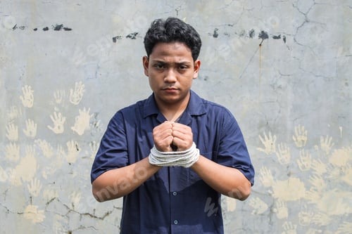 Preview: Young Asian Man With His Hands Tied By Thick Rope Standing