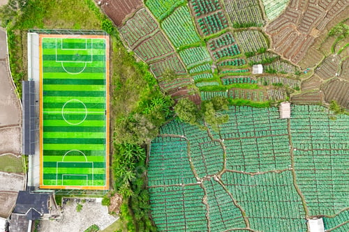 Preview: Aerial View Of Striped Football Pitch Located Next To Extensive Agricultural Fields
