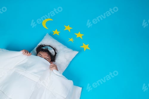 Preview: Young Asian Man Peeking Over His Duvet While Lying In Bed With A Sleep Mask