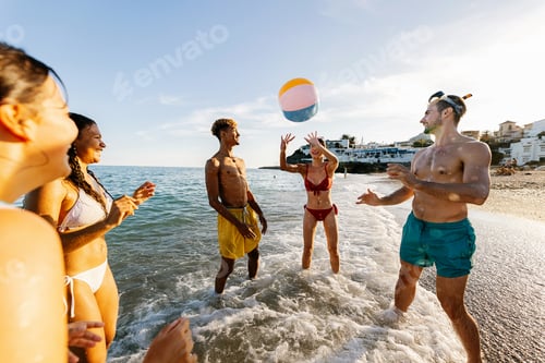 Preview: Friends playing beach ball enjoying summer vacation by the sea