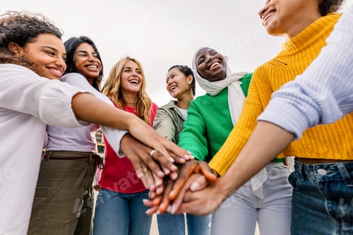 Preview: Group of diverse women stacking hands outdoors