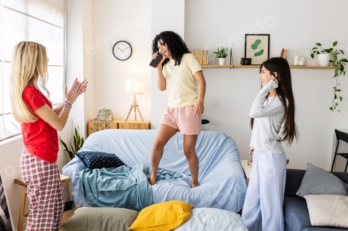 Preview: Young women having fun at a slumber party singing karaoke