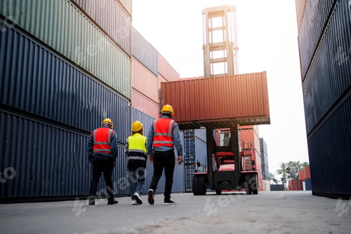 Vista previa: Three men in orange vests walk in front of a large container truck