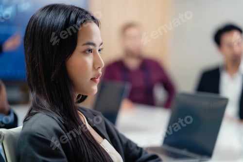 Preview: A close-up view of an attractive Asian businesswoman looking contemplative while attending a busines
