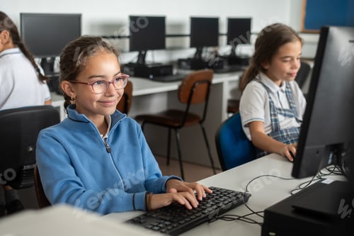 Preview: Smiling Elementary School Girl Using Desktop Computer