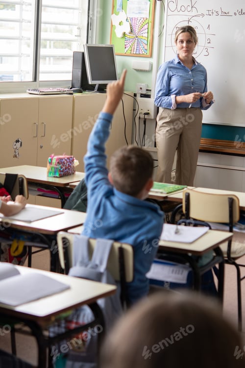 Preview: Elementary School Student Raising Hand During Classroom Lesson with Teacher