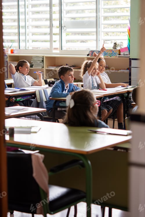 Preview: Elementary School Students Raising Hands to Answer Question in Classroom