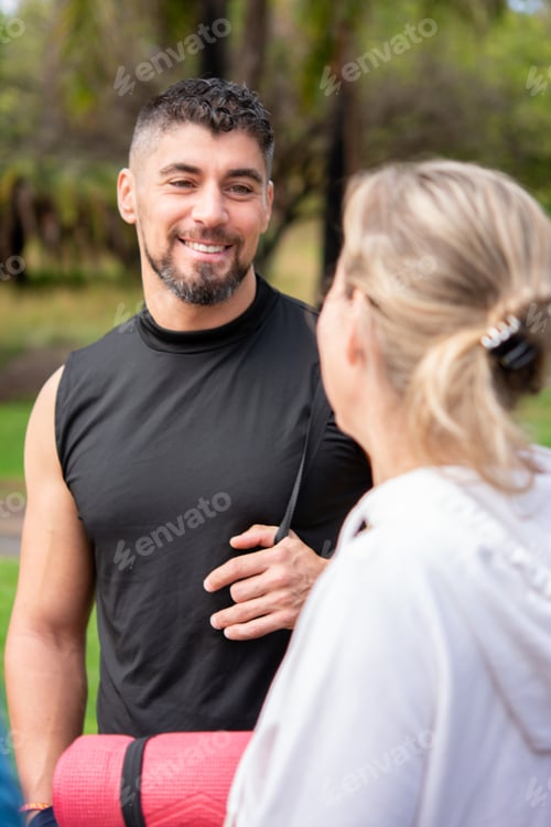 Preview: Smiling Man and Woman Talking Before Outdoor Workout Session