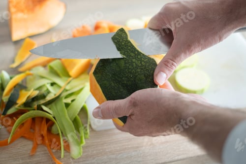 Preview: Hands Peeling a Green Pumpkin with a Chef Knife