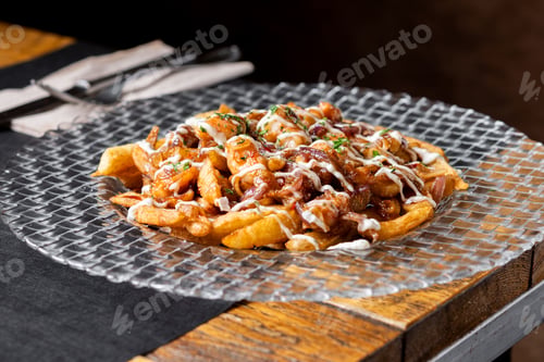 Preview: Loaded french fries with chicken, caramelized onion and sauce served on glass plate