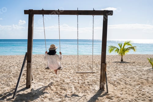 Preview: Woman swinging on beach enjoying tropical Saona Island vacation