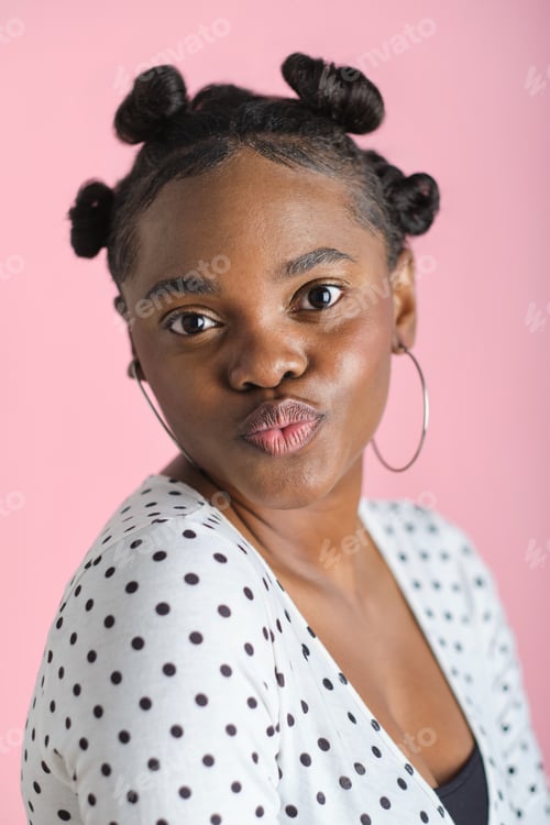 Preview: headshot portrait of Young black woman pouting wearing bantu knots