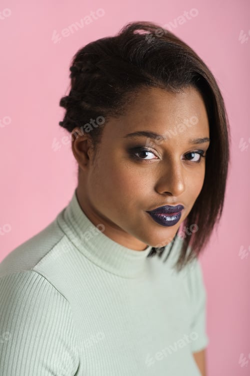 Preview: headshot of Young woman with bold makeup looking at camera