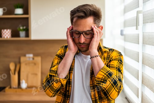Preview: Stressed Man Holding His Head With a Headache in the Kitchen
