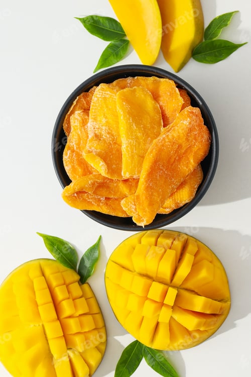 Preview: Dried mango pieces with fresh slices nearby