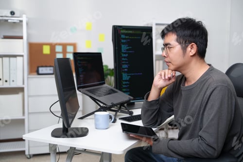 Preview: Developer Engaged in Coding and Problem Solving at a Workspace with Multiple Screens