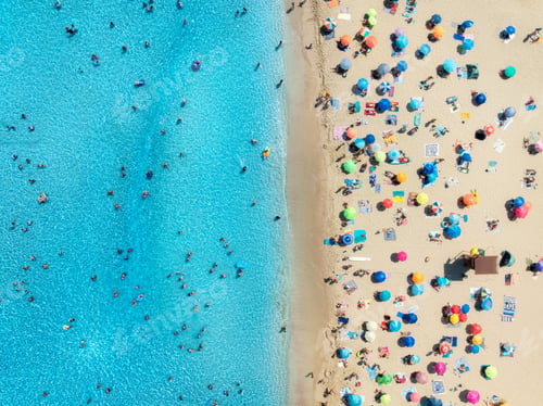 Preview: Aerial view of colorful umbrellas on sandy beach, swimming people