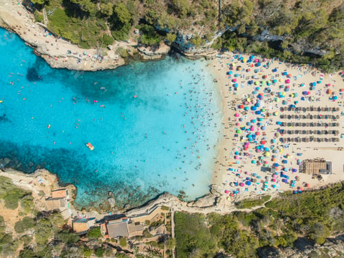 Preview: Aerial view of colorful umbrellas, crowded sandy beach, blue sea