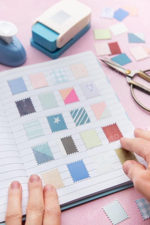 Preview: Hands creating a scrapbook with decorative paper punches