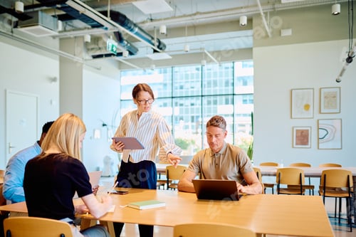 Preview: Business colleagues collaborating on project in modern office