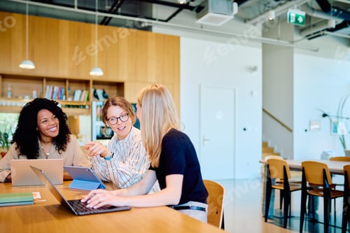 Preview: Women collaborating on laptops in modern office space