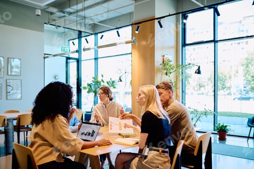 Preview: Diverse team collaborating on business project in modern office