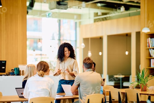 Preview: Black woman leading a business team meeting in modern office